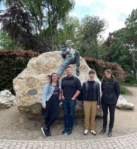 Opettajat seisovat Oscar Wilde patsaan edessä.