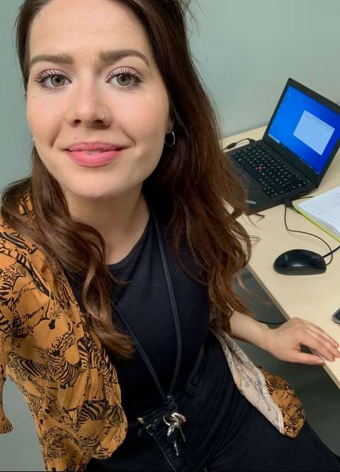 Johanna katsoo kuvassa kameraan työpöytänsä ääreltä. 