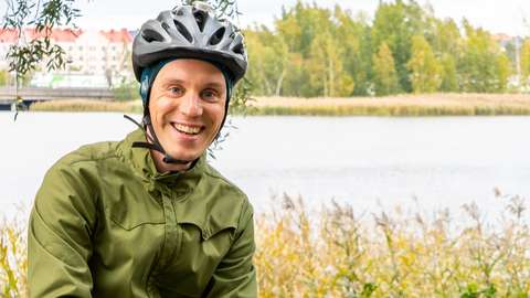 A smiling man with his bike. 