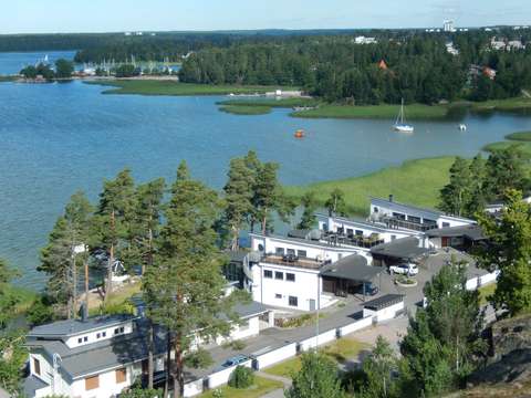 Småhus vid havet. Havsängar, tallar, skog i bakgrunden. 
