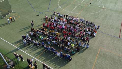 Ilmakuva, jossa näkyy ykköset kokoontuneina kentälle päivän aloitukseen. 