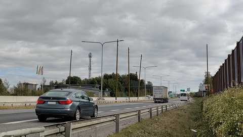 Länsiväylä jolla ajaa autoja ja jonka keskikaistalle ja reunoille on pystytetty puisia tolppia.