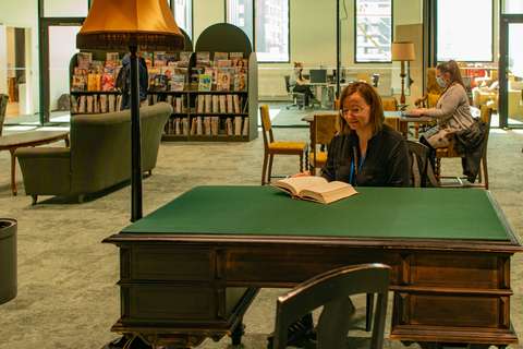 Piia Isoaho lukemassa työpydän ääressä.