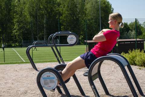 En kvinna på utomhusgym.