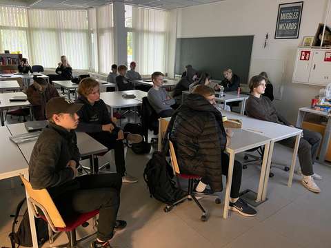 Opiskelijat seuraavat luokassa etävierailijoita.