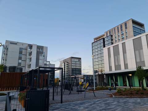 Stadsvy från Esboviken. I förgrunden finns en lekplats och i bakgrunden finns flerbostadshus.