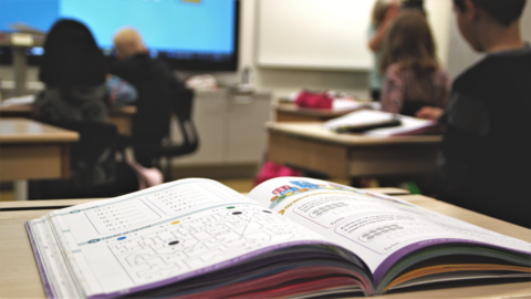 Koulukirja avattuna pulpetilla. 