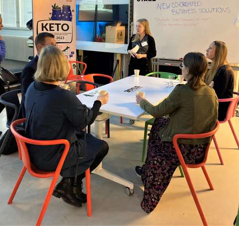 Ihmiset istuvat pöydän ympärillä keskustelemassa