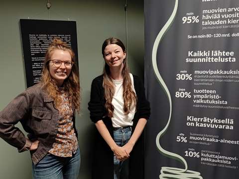Outi Hynynen and Mia Johansson standing in front of info boards about the circulation of plastics.
