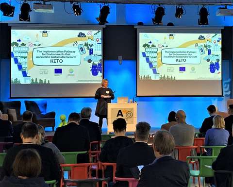 Henkilö puhuu yleisön edessä lavalla. 