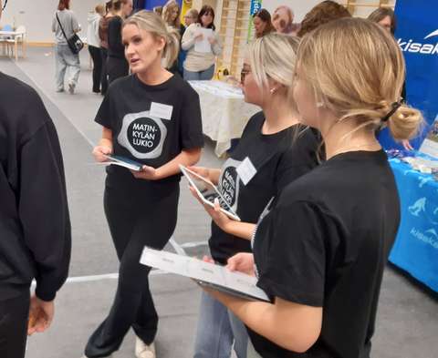 tutorit seisovat messuille