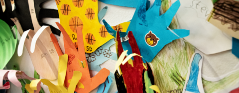 Oppilaiden askartelemia erivärisiä paperisia käsiä.