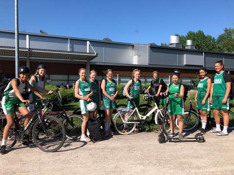 Iloisia tyttöjä pyörien kanssa peliasut päällä