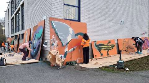 opiskelijat maalaavat teosta koulun pihalla