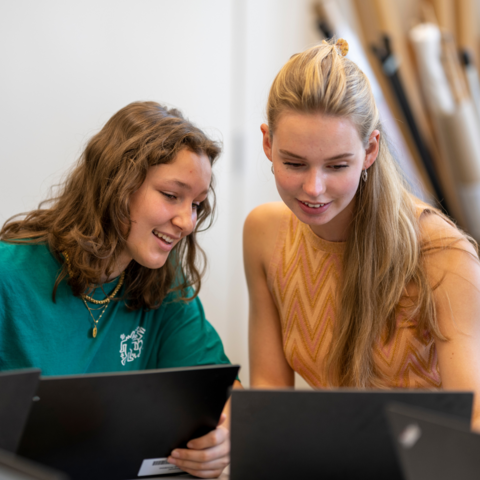 Kaksi nuorta tietokoneilla. 