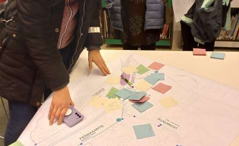 Kartta, kädet ja post-it lappuja liikenteen keskstelupisteellä