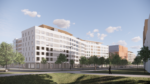 Vaaleita kerrostaloja ja puita kadun varrella.