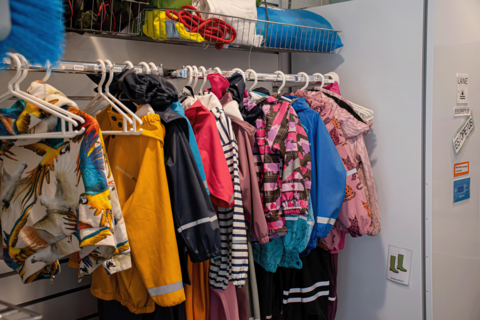 Barnens kläder som hänger från klädhängaren.