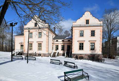 Albergan kartano päärakennus lumisena talvena auringon paisteessa.