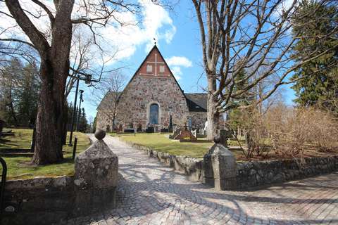 Espoon tuomiokirkko etäällä mäenpäällä keväällä auringon paisteessa.