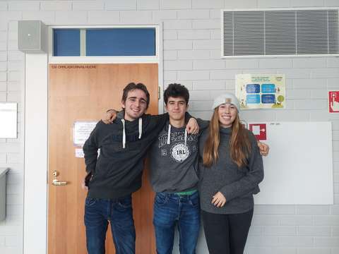 kolme espanjalaista opiskelijaa seisoo yhdessä koulun käytävällä kuvattavana