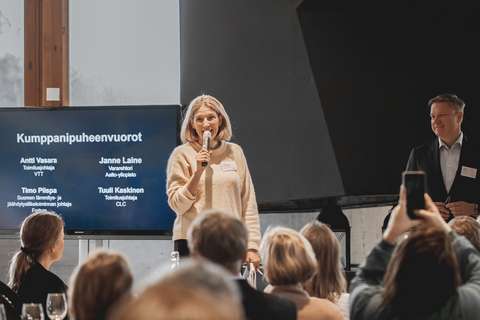 Tilannekuva puheenvuorosta. Kuvassa näkyy yleisöä ja kaksi henkilöä lavalla.