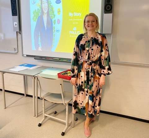 Anu Pires seisoo luokassa valkokankaan edessä