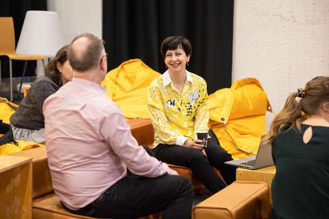 Hymyileviä ihmisiä pienryhmäkeskustelussa