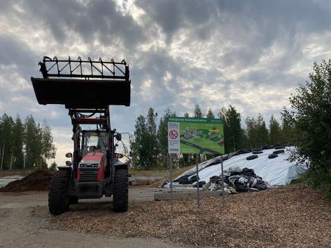 Traktori kauha ylhäällä biokaasulaitoksella.