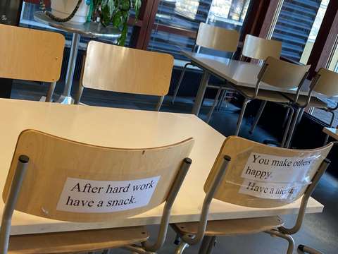 koulun ruokalan tuoleissa ystävälliset lauseet eri kielillä: After hard work have a snack. You make others happy, have a nice day.