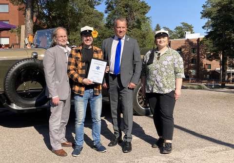 Sampo Suihko, Veeti Kahilainen, Jukka Mäkelä and Ida Parkkinen are standing side by side and look towards the camera. Veeti Kahilainen is holding the certificate for the Borough of the Year. The picture is taken outside.