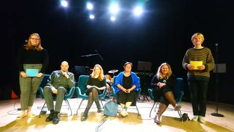 panelistit istuvat lavalla