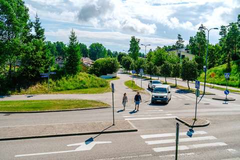 Two people crossing the road in a small house area in Espoo.