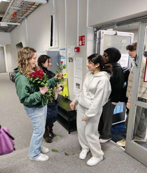 Etis ib1 students give roses to students entering the examination room