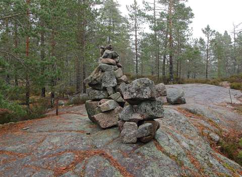 Kallionlaki, jonka päällä pinottuja kiviä, taustalla metsää.