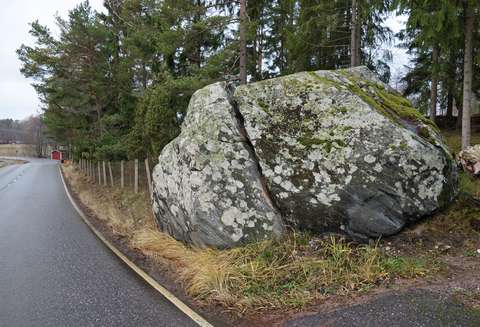 Kahteen osaan haljennut siirtolohkare aivan asvaltoidun tien varrella.