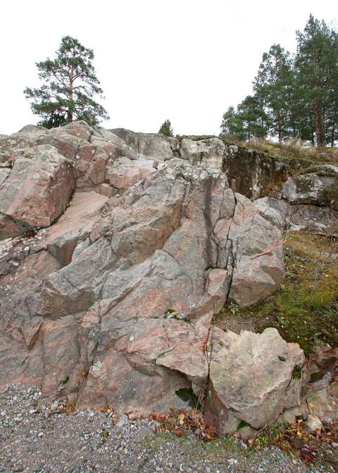 Punaisesta kivestä muodostunut rosoinen kallio.