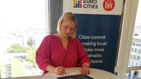 I mitten av bilden är en kvinna som skriver på ett papper.