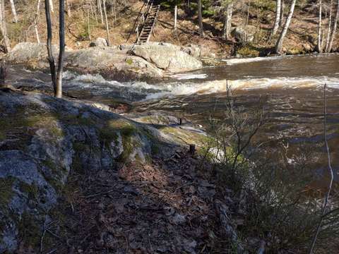 Rautatappeja kalliossa metsässä lammen rannalla.