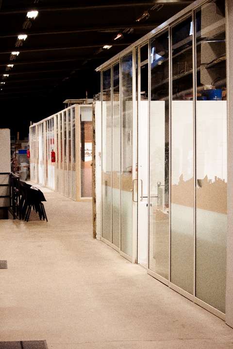 Bild av en kontorskorridor vars rum har glasväggar av återvunna glaskonstruktioner.