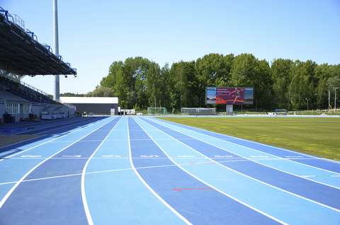 Kuvassa näkyy yleisurheilustadionin juoksuradan suora. Radat ovat sinisiä. Vasemmalla puolella näkyy katettua katsomoa. Kentän takana kasvaa puita.