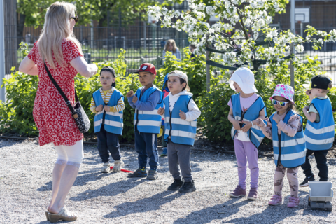 Lapset seisovat rivissä ja tekevät jumppaliikkeitä opettajan johdolla.