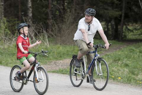 Kuvassa on mies ja poika pyöräilemässä Oittaalla.