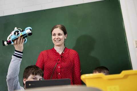 Maija Vehmanen in a classroom in front of the blackboard.