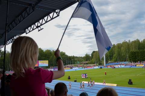 Lapsi heiluttamassa Suomen lippua Leppävaaran Stadionin katsomossa Yleisurheilun nuorten alle 23-vuotiaiden EM-kilpailuissa.