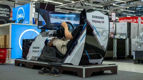 A man playing digital games in a driving simulator.