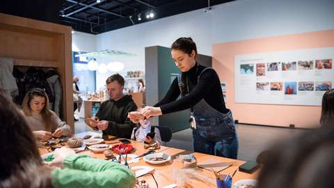 Pyödän äärelle kokoontuneita aikuisia ja lapsia askartelemassa.