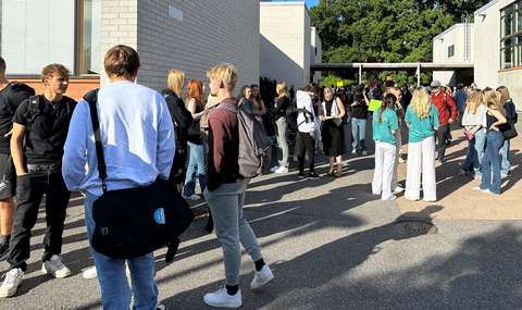 opiskelijat seisovat ja juttelevat koulun pihalla