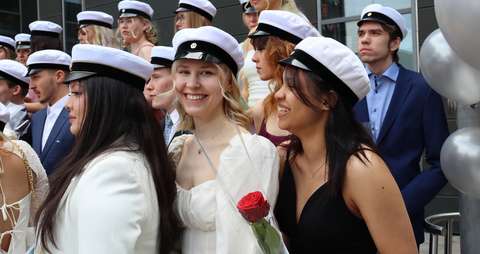 Ylioppilaat hymyilevät kameralle.