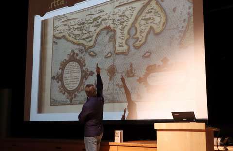 luennoitsija näyttää vanhaa karttaa valkokankaalle